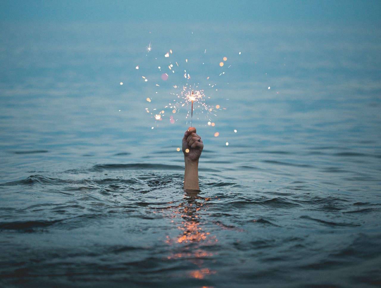 hand with sparkler in water