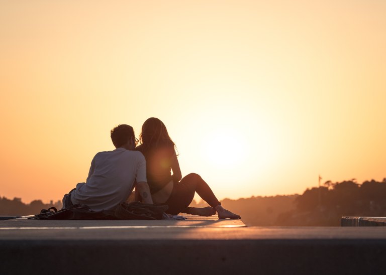 couple sitting together at sunset