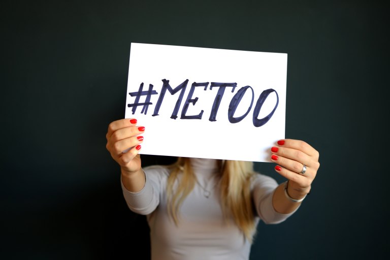 Woman holds up sign that says #metoo