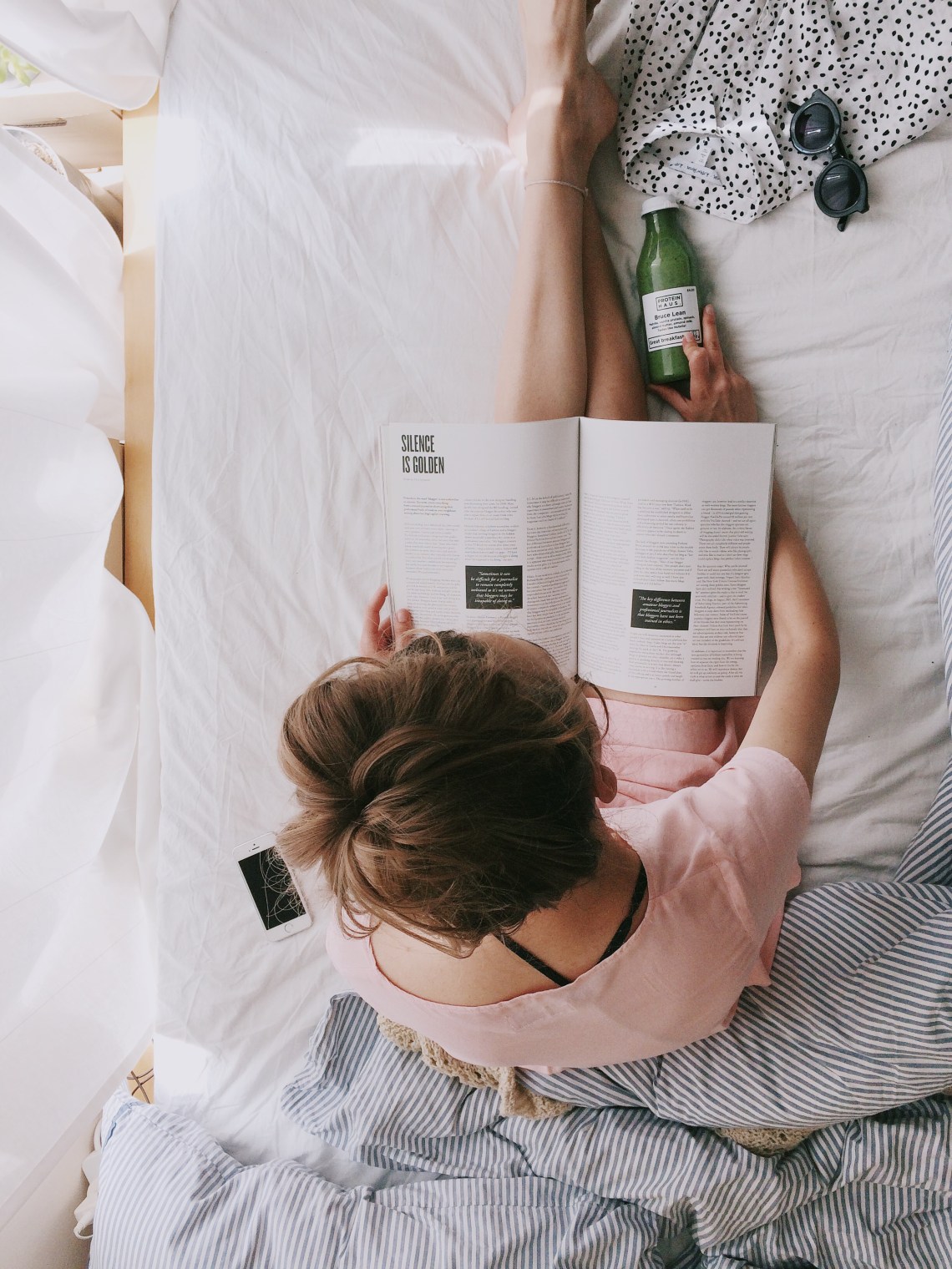 girl with a green juice and a magazine