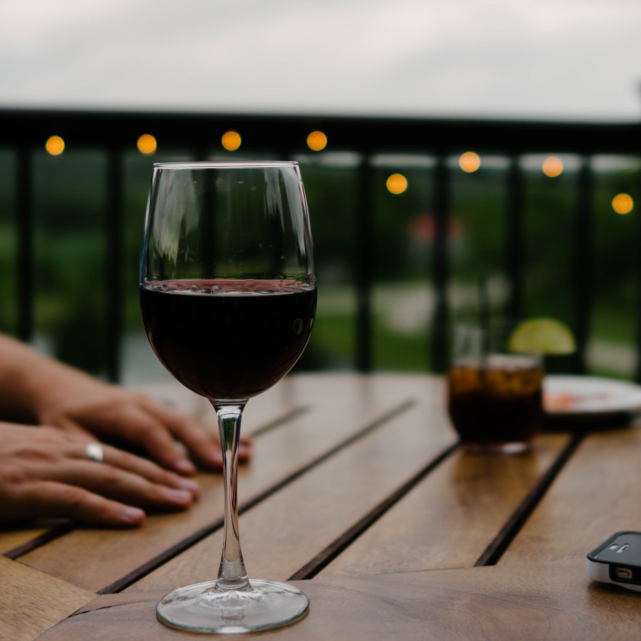 person with red wine on porch