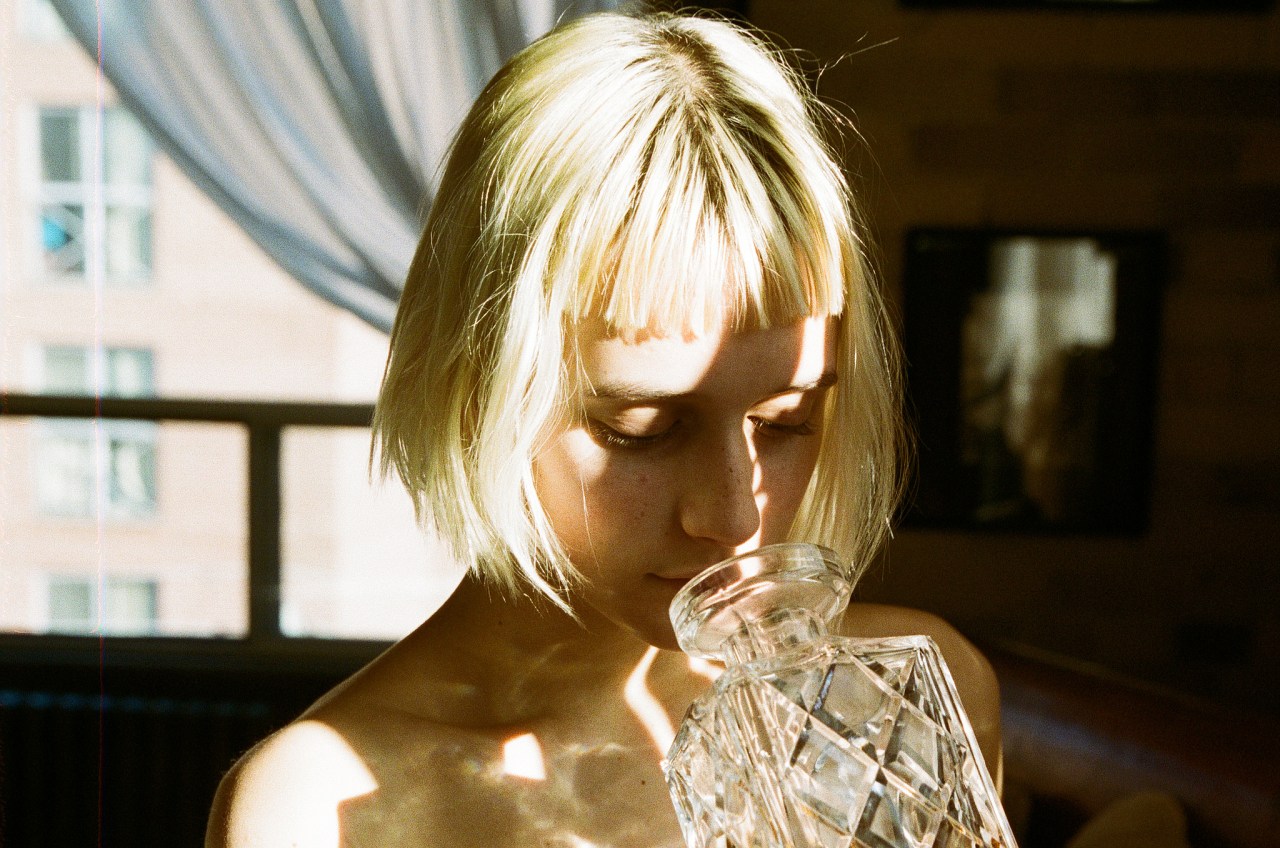 girl sniffing an old bottle