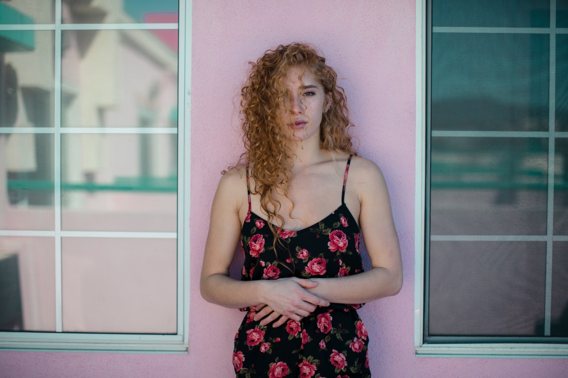 woman with curly hair hands on the stomach