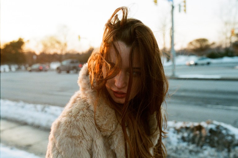 Pretty woman in a fur coat with her hair in her face