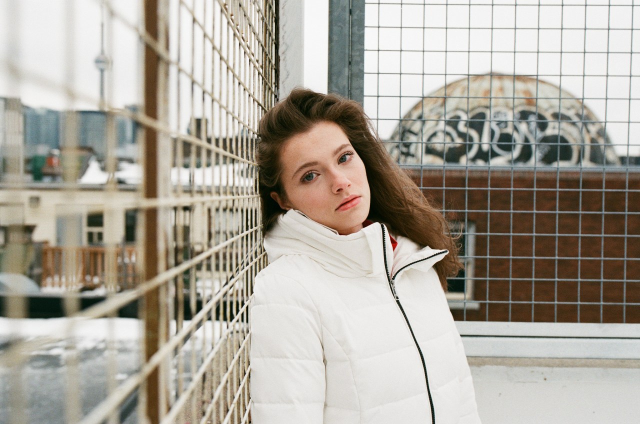 sad girl leaning against fence