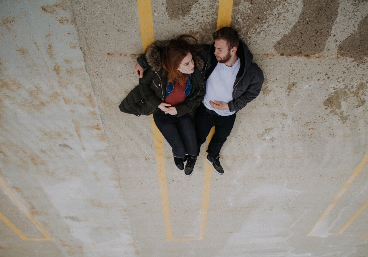 couple laying down in parking lot