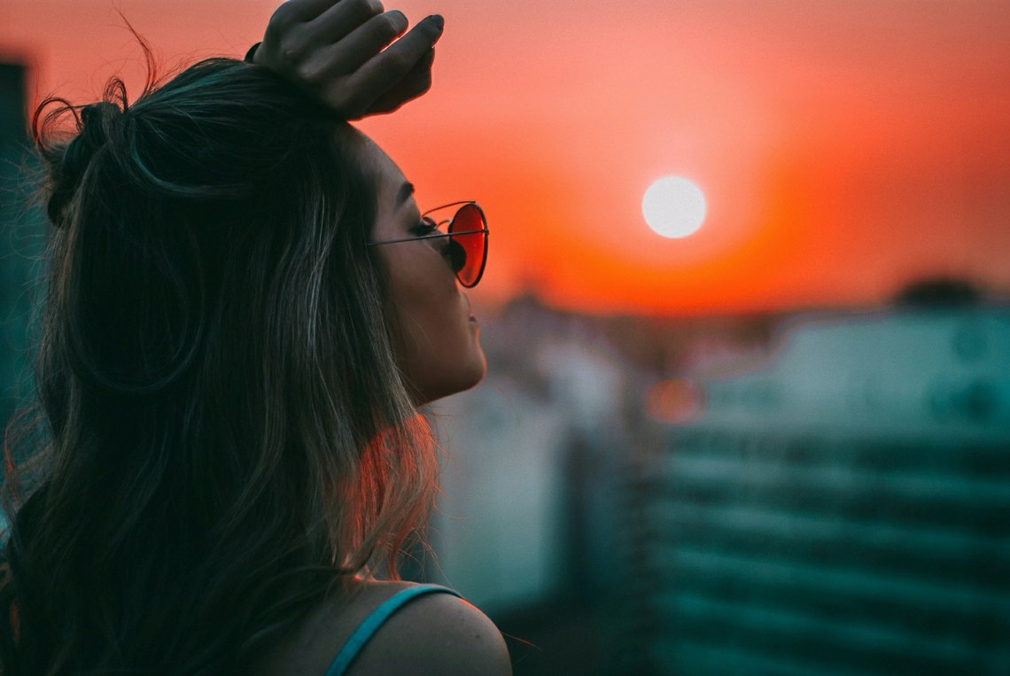 Woman standing alone by sunset