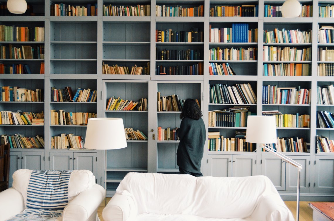 Woman walking through bookshelves