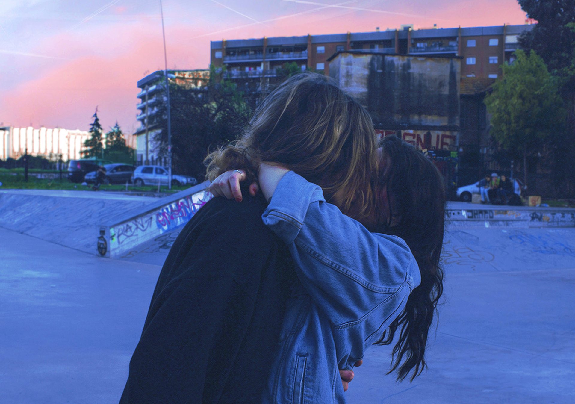 Couple kissing, embracing surrounded by concrete and graffiti