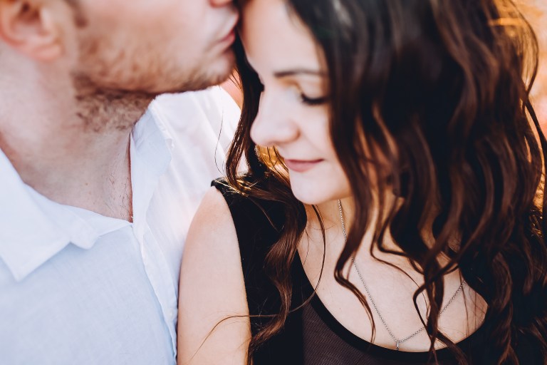 couple close up intimate kissing on forehead