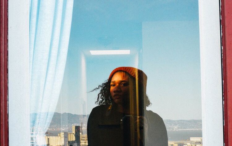 woman standing looking at reflection in window