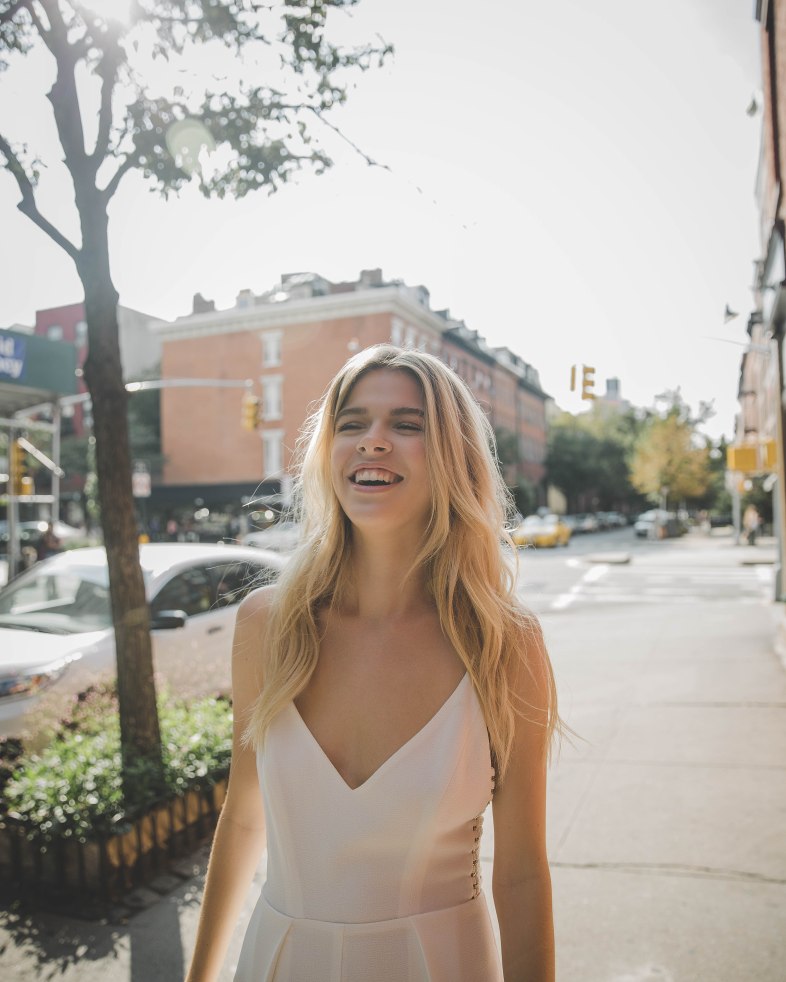 woman in white dress walking on sidewalk