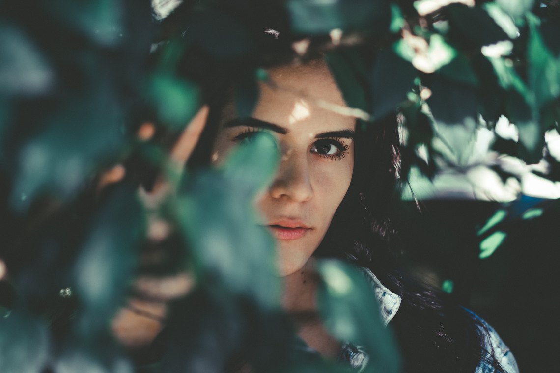 woman looking through branches