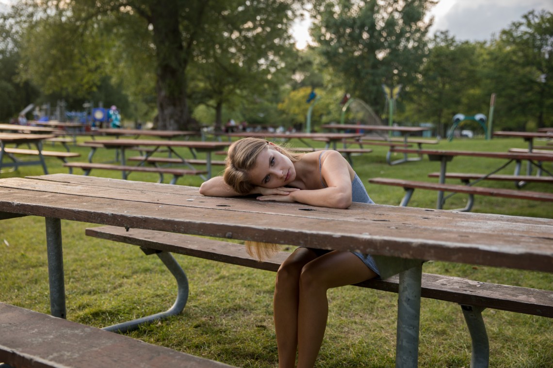 Damsel in Distress Solitarily Rests Her Head on the Picnic Table