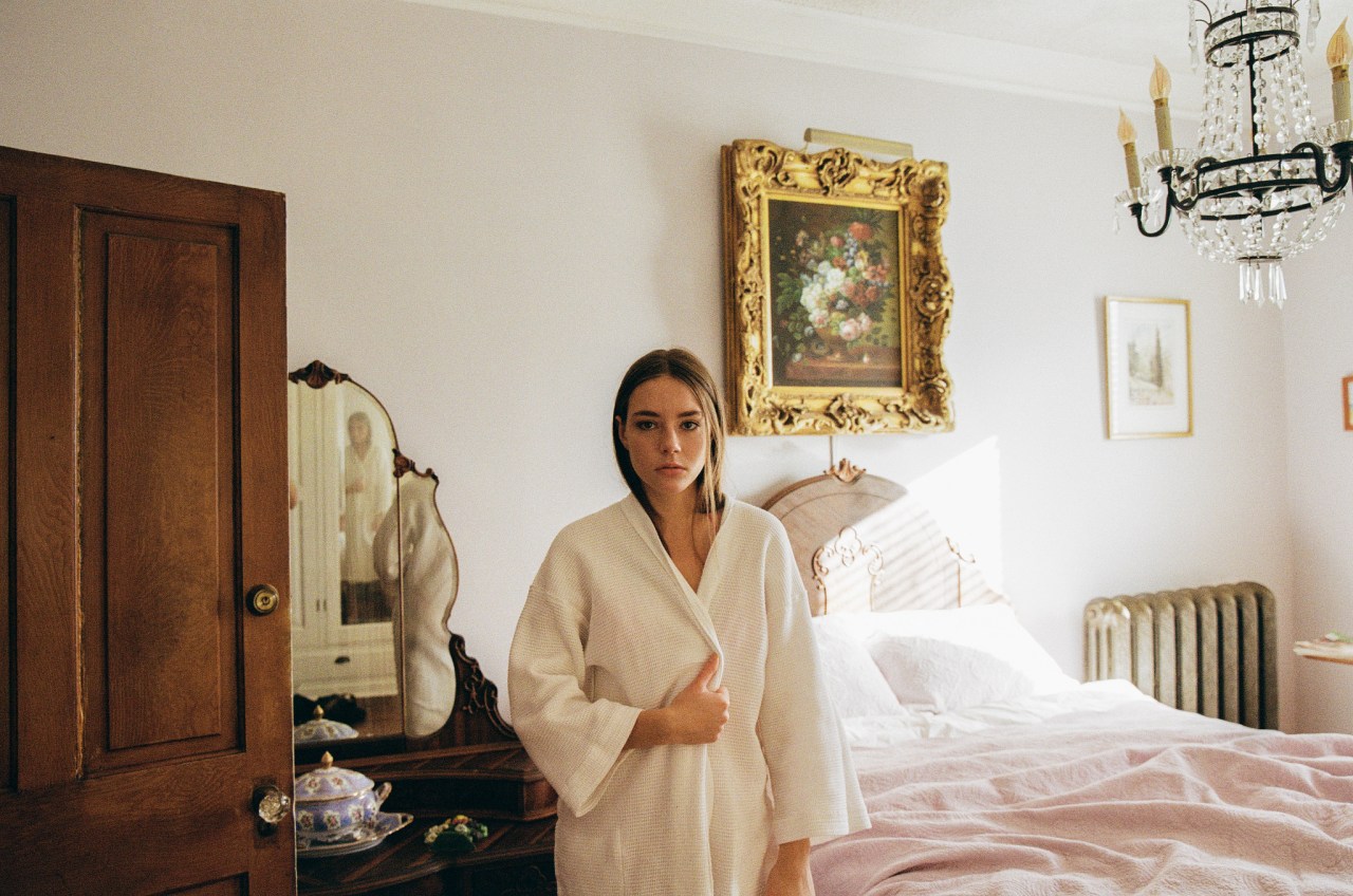 girl standing in robe in hotel room