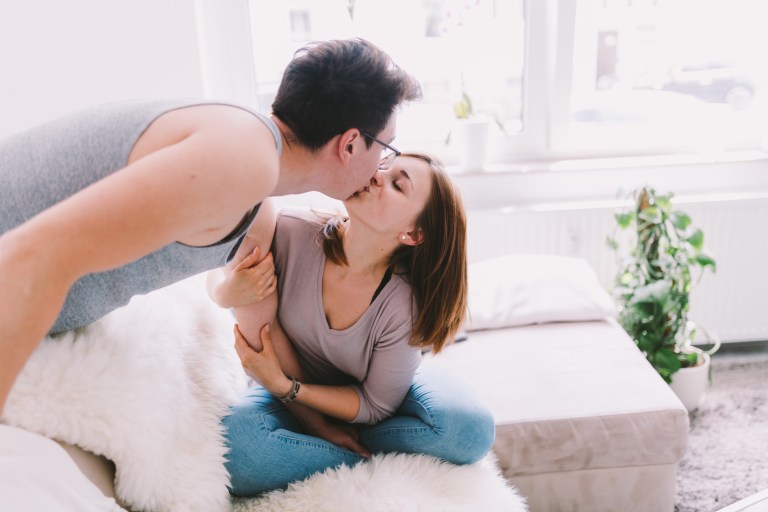 woman and man kissing on couch