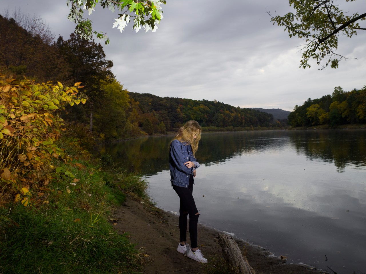 sad woman standing by water