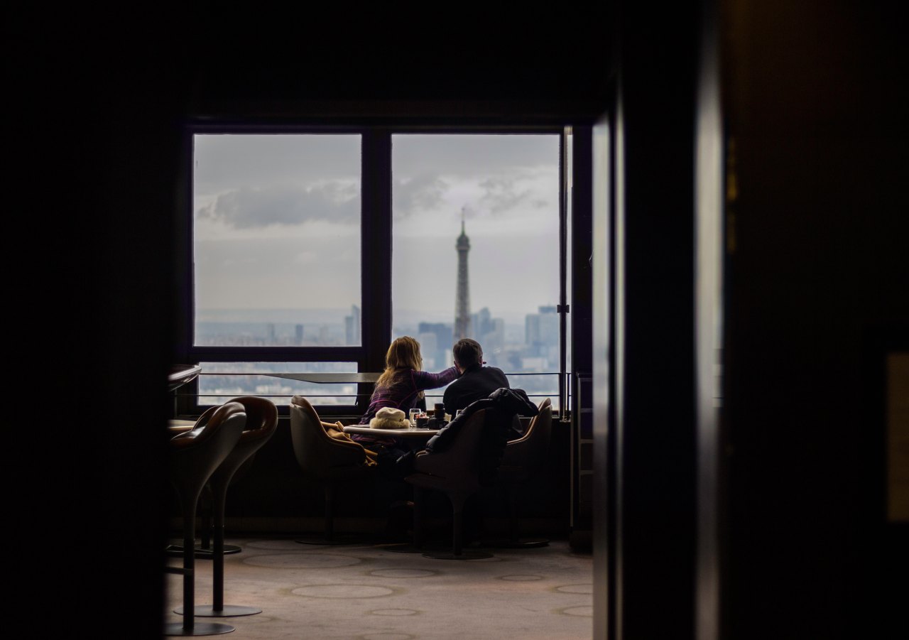 A couple sit on a couch looking out the window at the needlepoint in Seattle