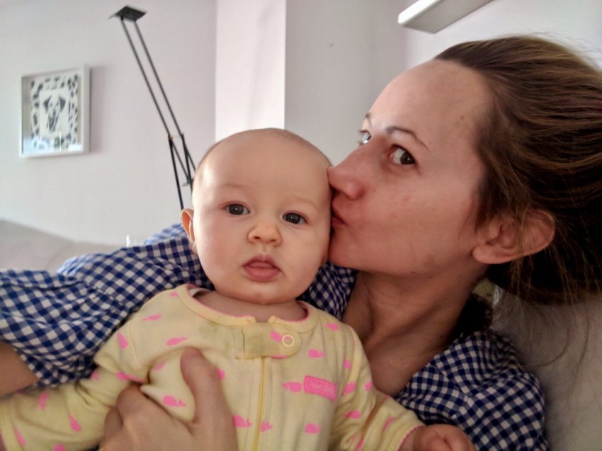 mom holding baby girl in bed