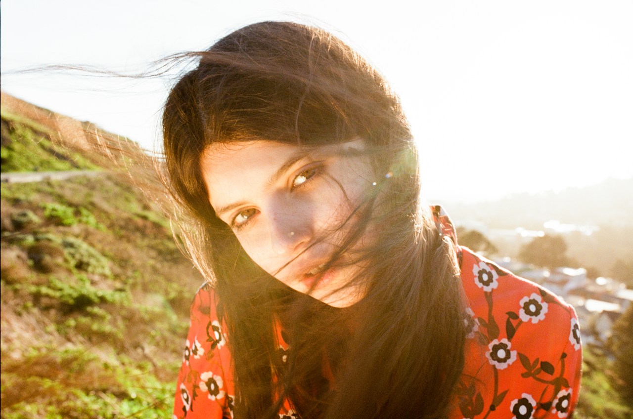 woman sitting in sun in red dress