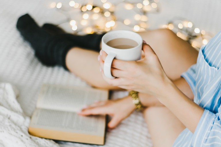 woman reading book with tea