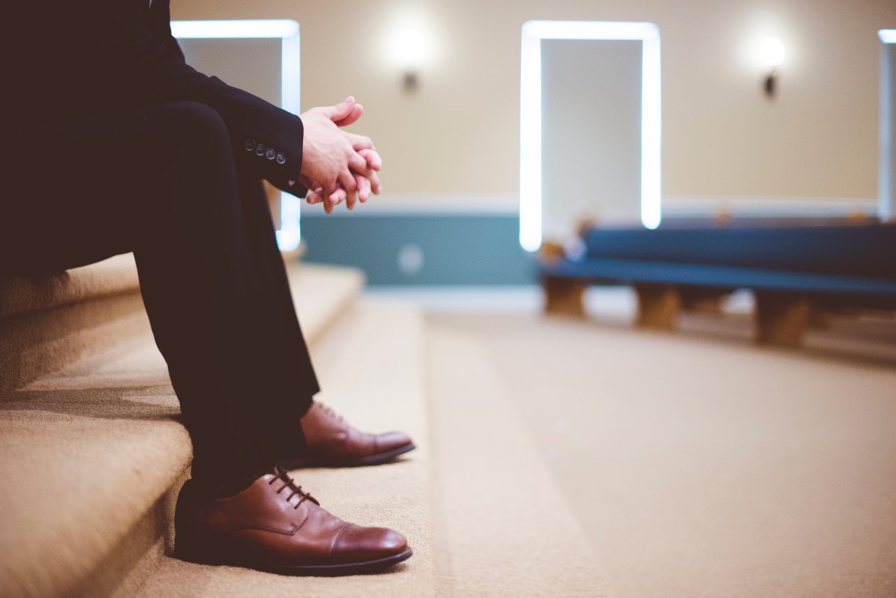 A man dressed in a suit sitting in a church