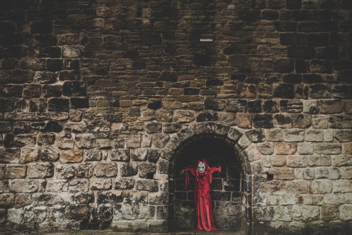 A stone wall with a scary looking demon