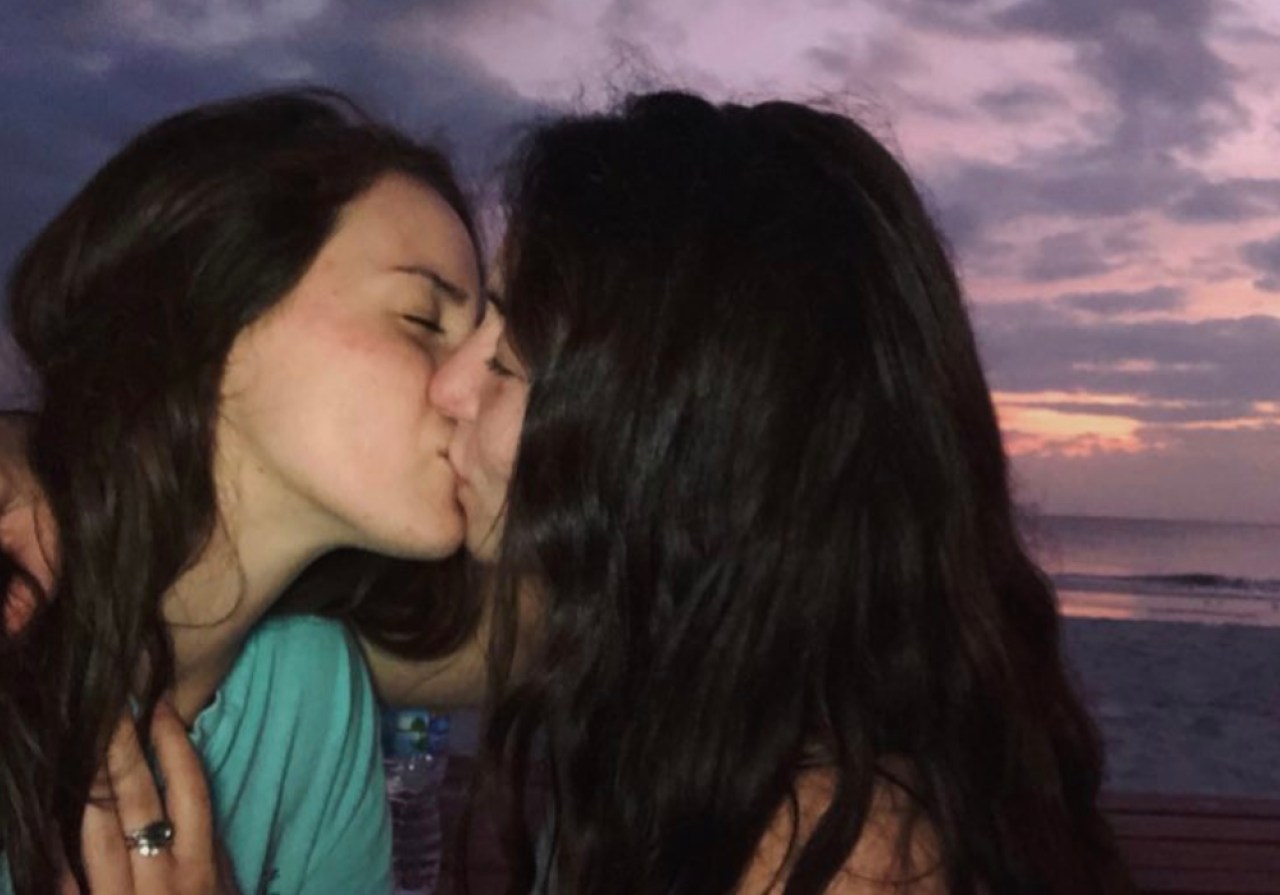 A woman and her girlfriend kissing