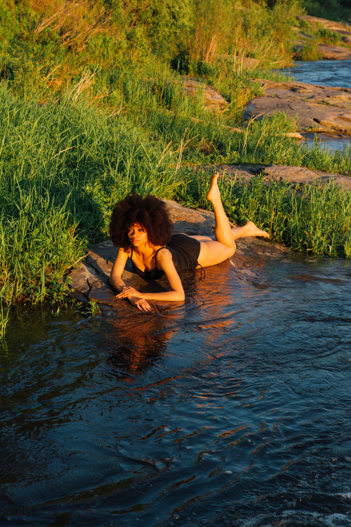 woman laying down in bathing suit by water