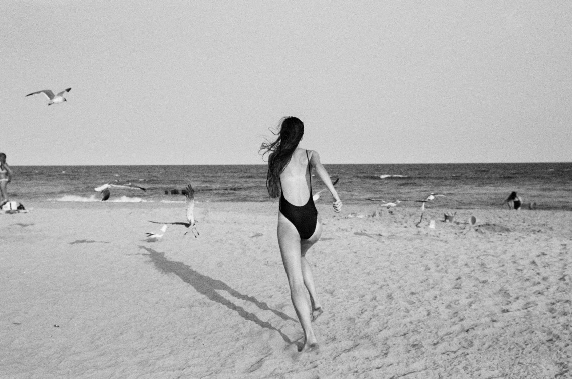 woman happily running on beach