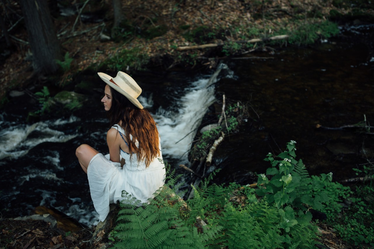 woman sitting along creek