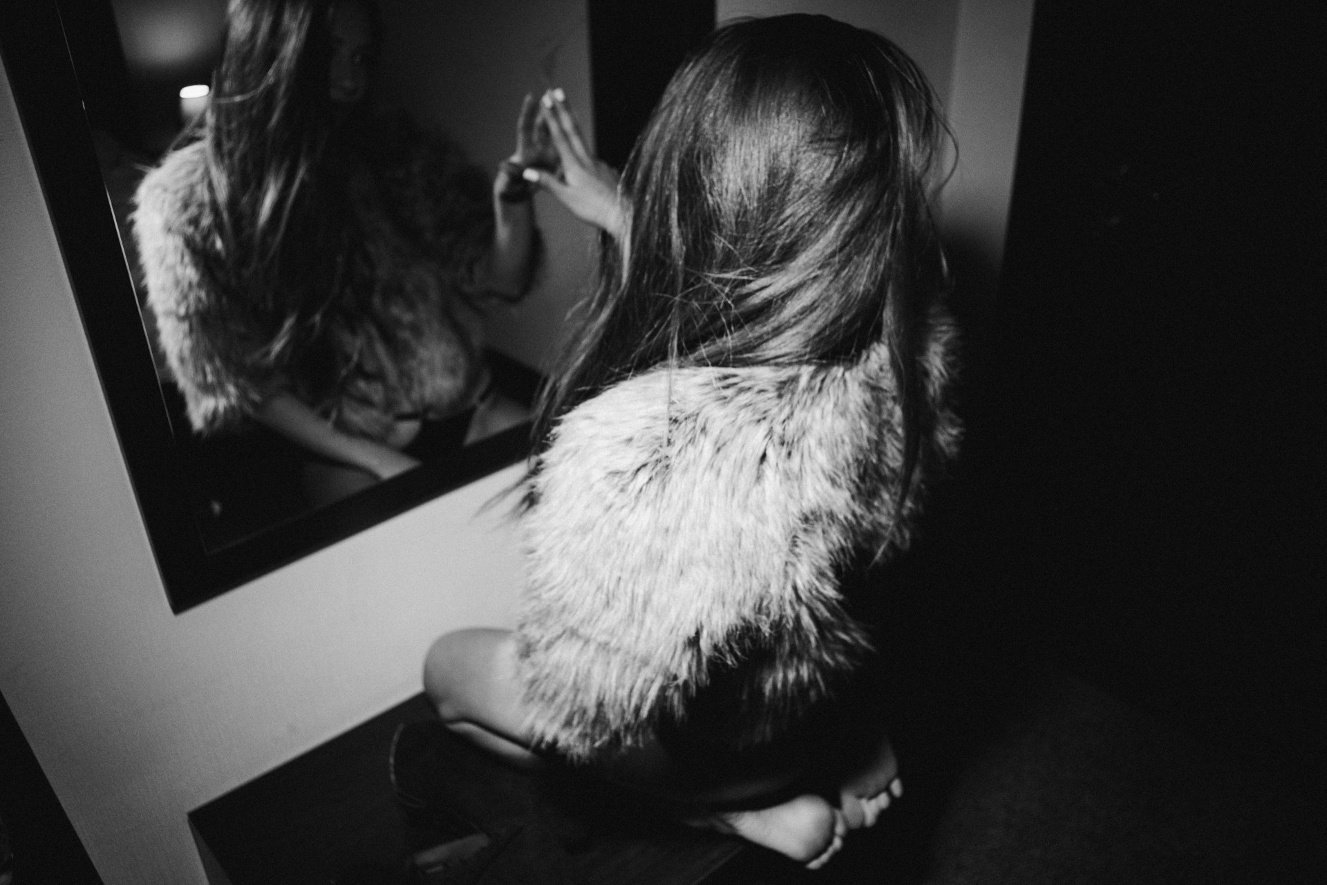 woman sitting in front of mirror