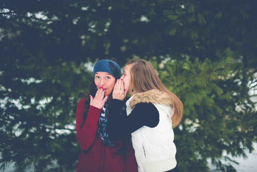 Friends whisper secrets in each other's ears