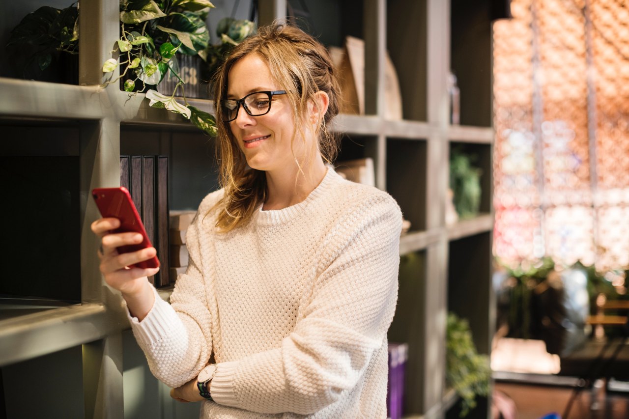 A woman looks at her phone and laughs