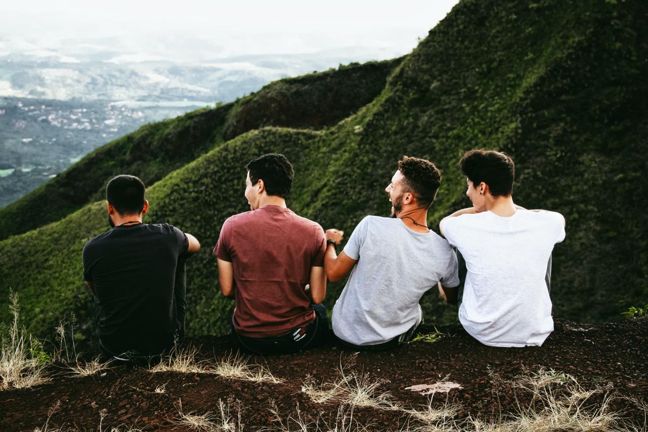 men laughing by green valley