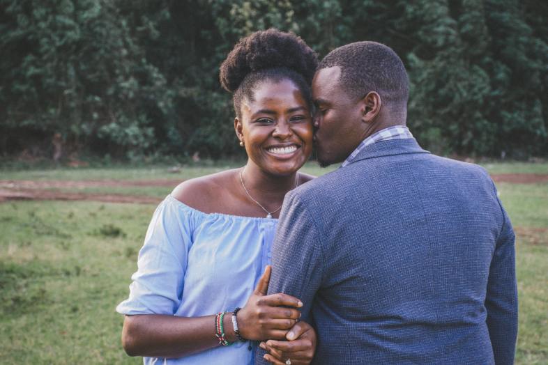 Man Kissing Left Cheek of Smiling Woman