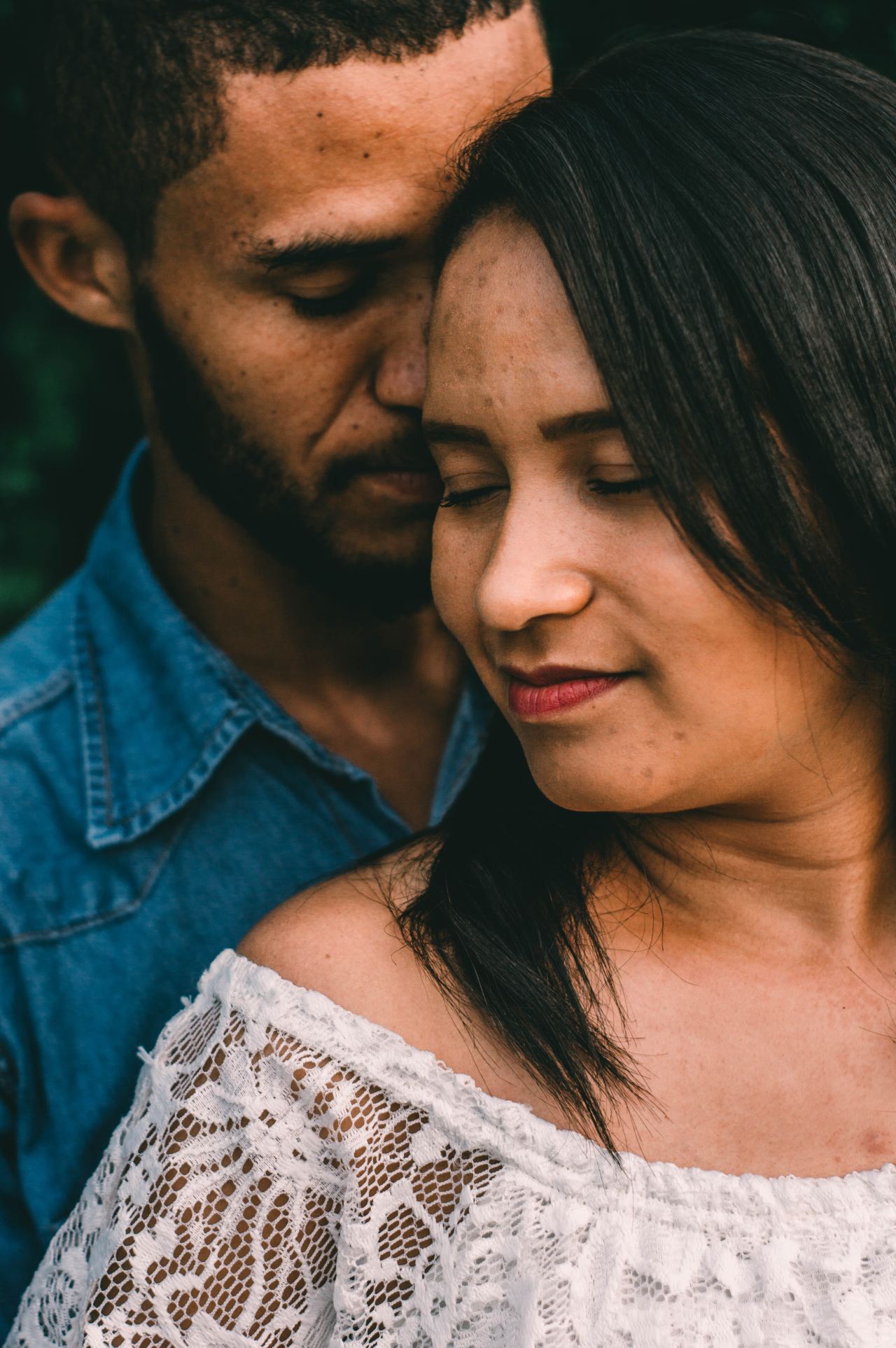 woman in white in front of man in blue denim jacket