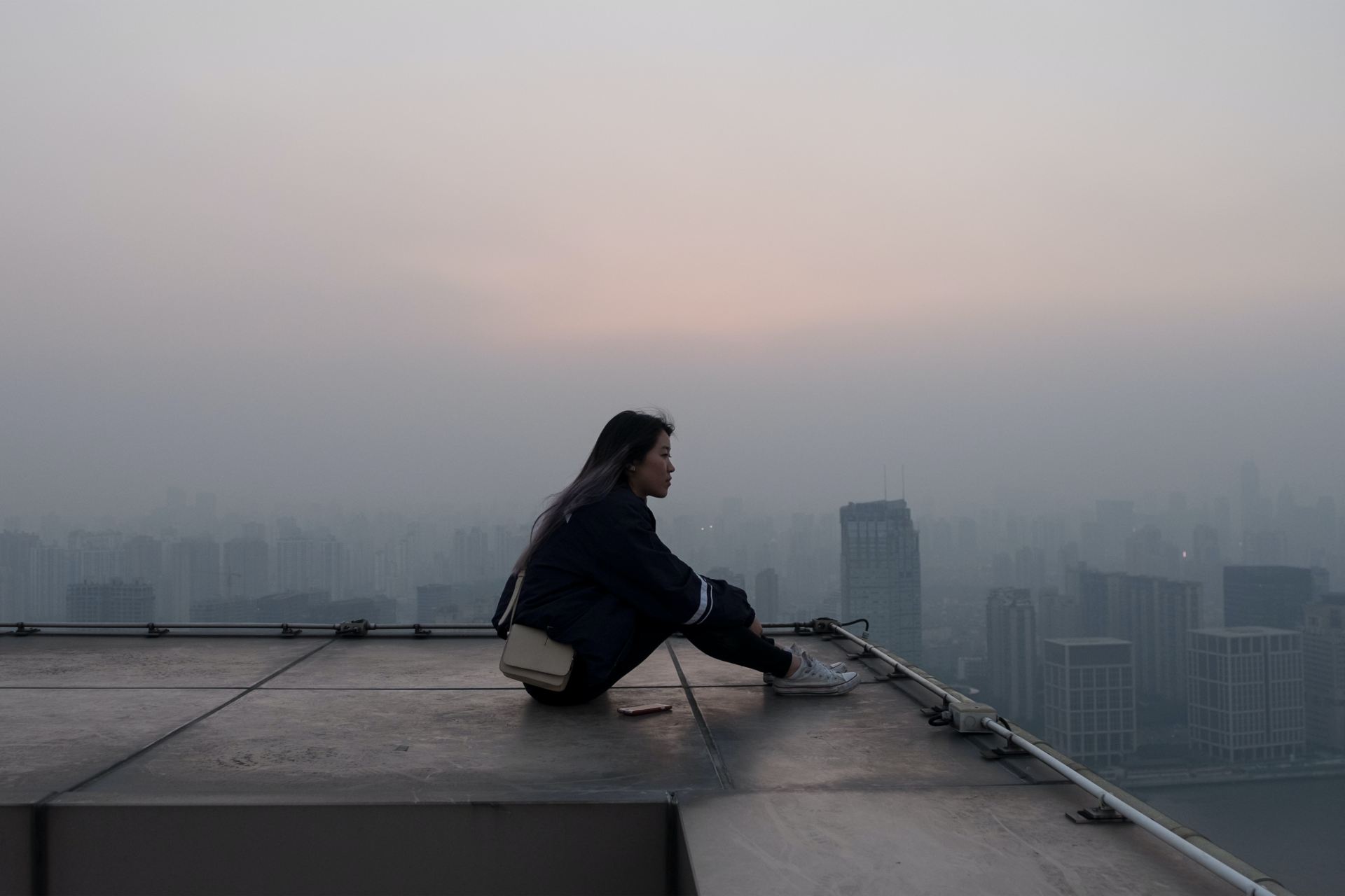 woman seating on skyscraper