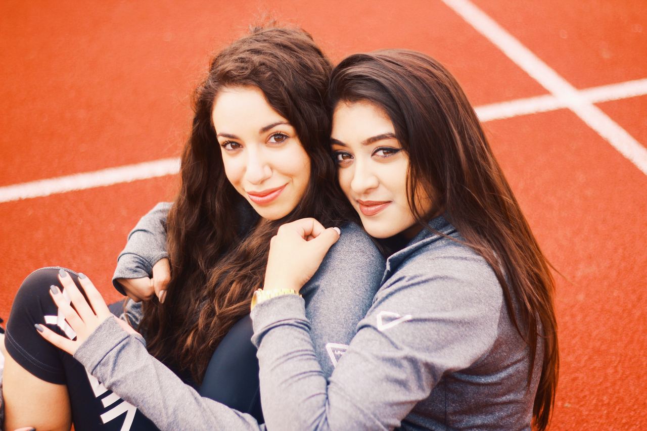 two women hugging each other on orange pavement