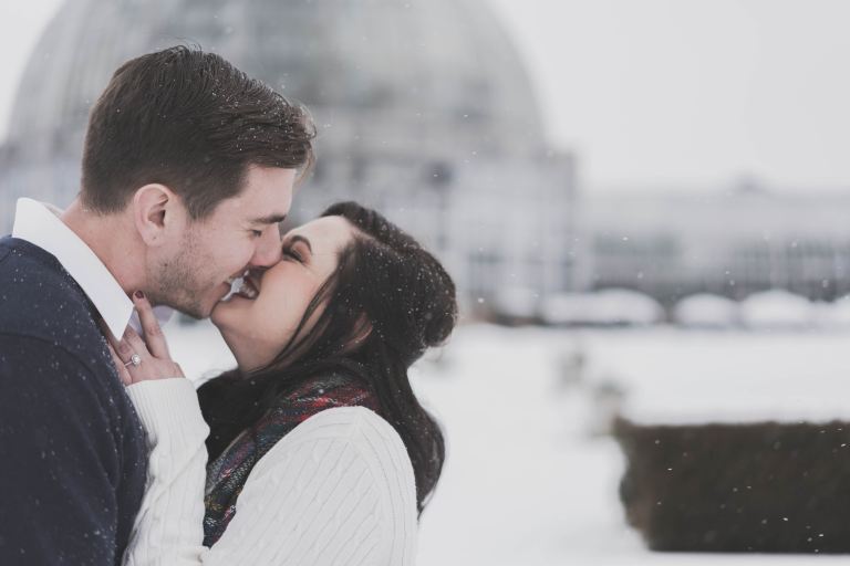 man and woman kissing in snow weather