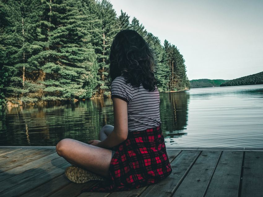 woman in black and white striped shirt sitting on dock during daytime