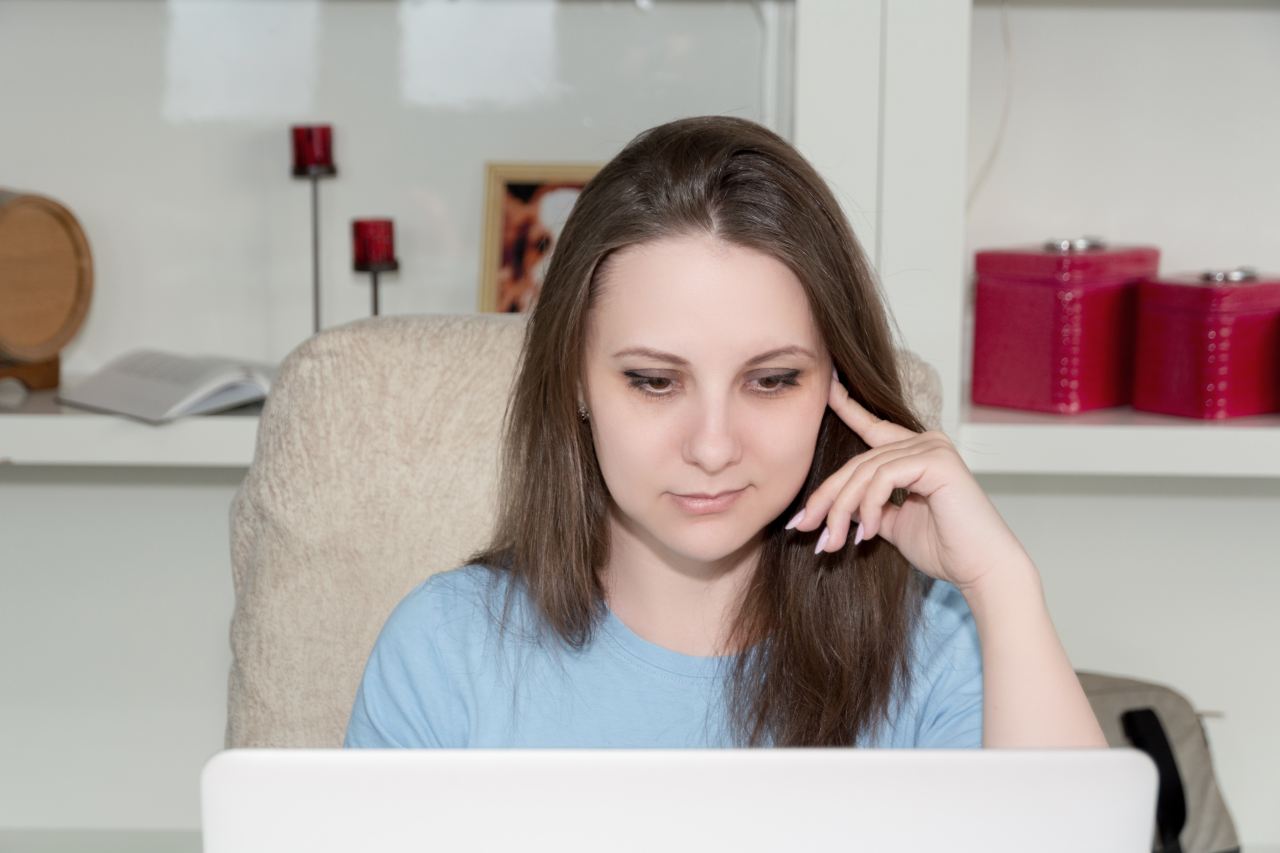 woman in blue crew neck shirt sitting on brown couch