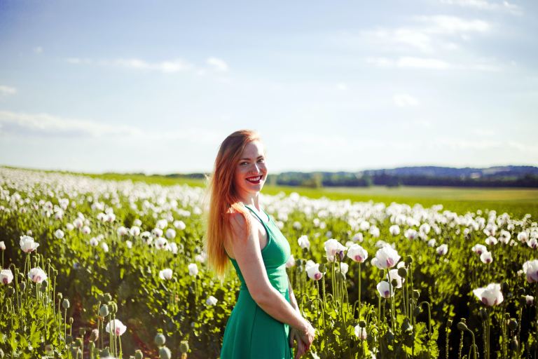 woman standing near white petaled flower field at daytime