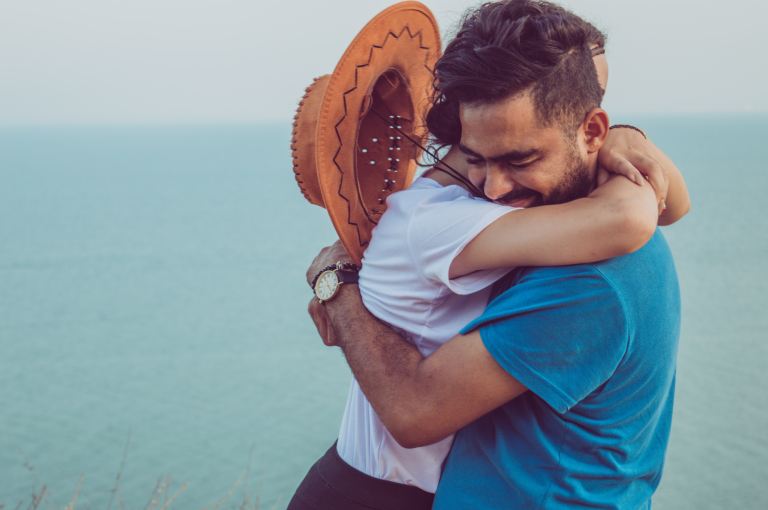 couple hugging on high ground overlooking the sea