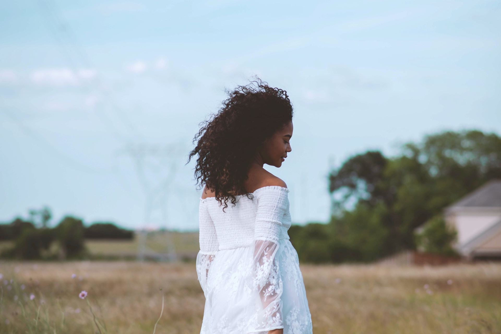 girl in white dress standing on green grass field during daytime