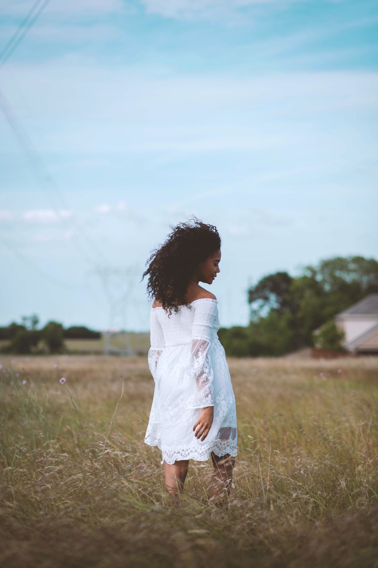 girl in white dress standing on green grass field during daytime