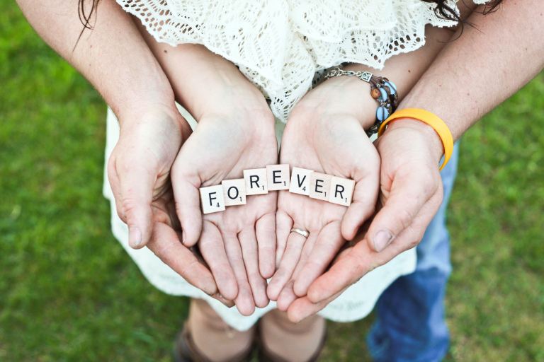 adult and girl holding forever scrabble letters during daytime