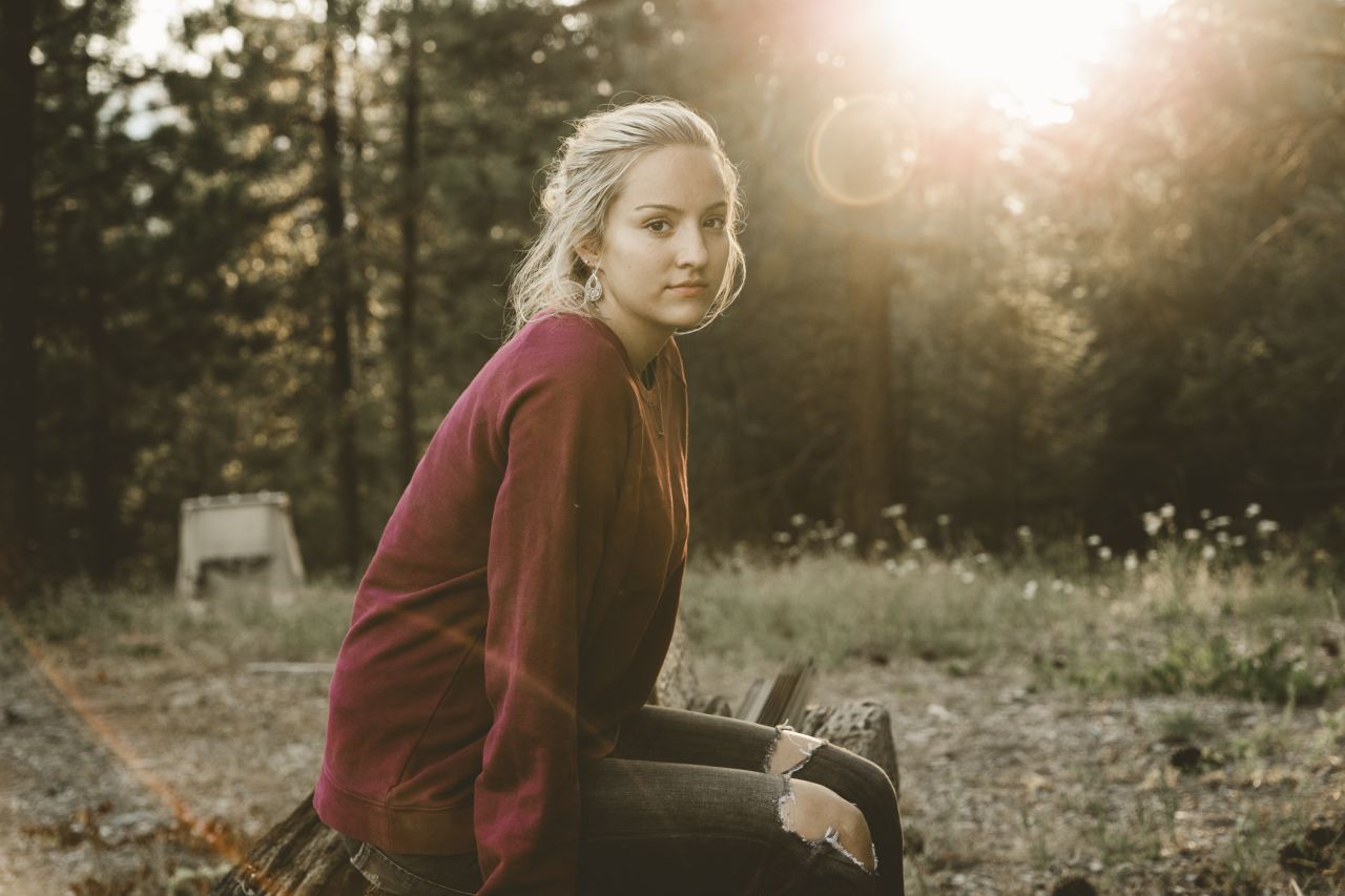 woman in maroon long-sleeved shirt sitting on bench