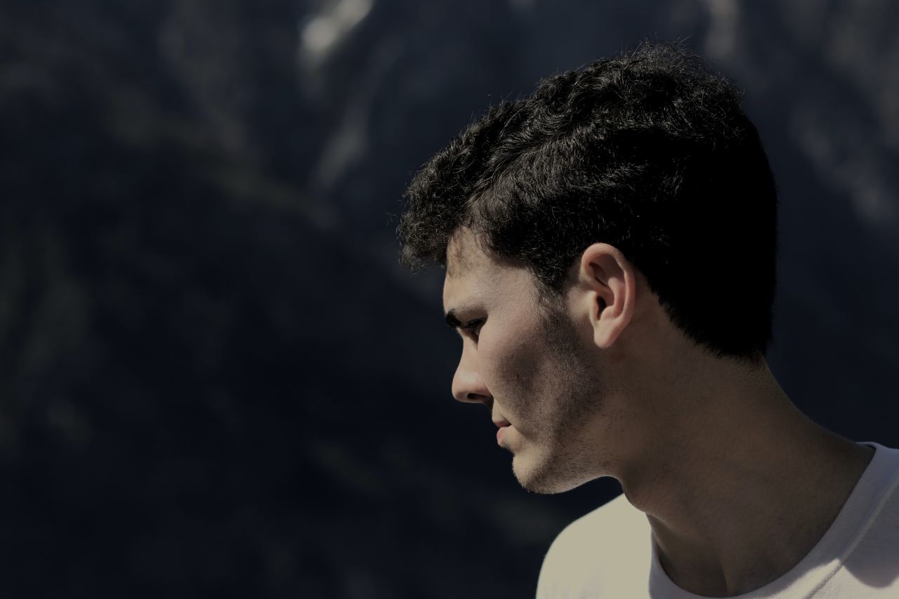 man standing at the edge of the cliff looking down