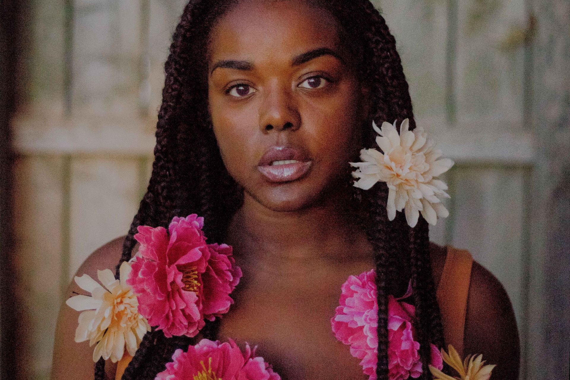 woman standing near white wall with multicolored flowers on her hair